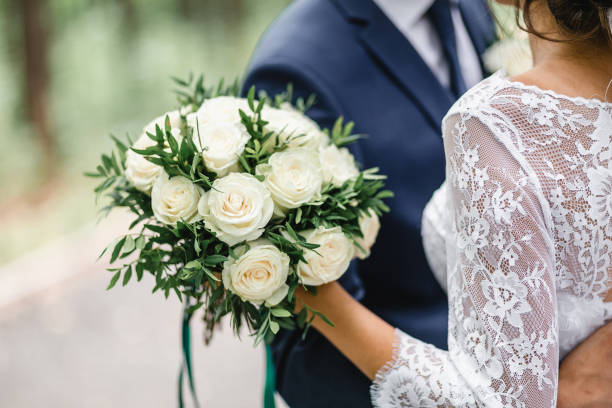 glückliche braut und bräutigam auf ihrer hochzeit umarmung - trauung stock-fotos und bilder