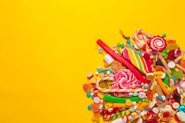 istock colored candies on yellow background 1147781503