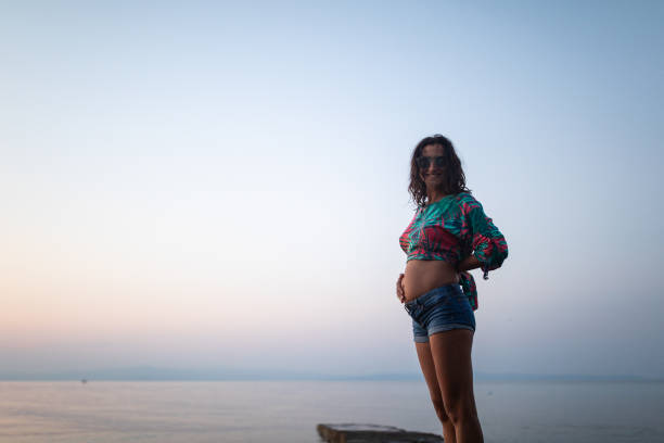 Beautiful Woman standing on pier , looking at camera and smiling, Halkidiki, Greece