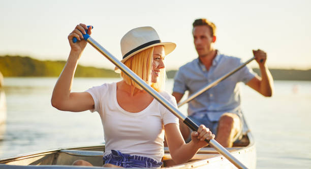 istock Smiling young couple paddling their canoe on a lake 1147784841