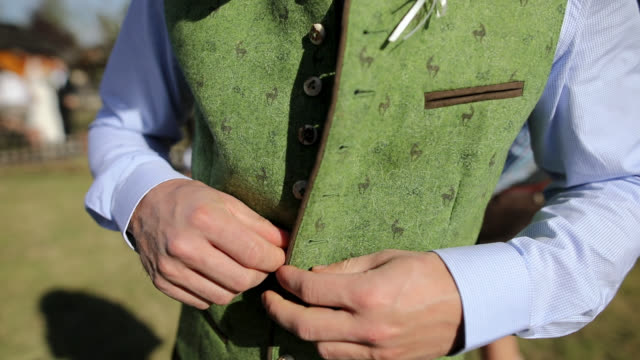 Bavarian Men Buttoning Traditional Clothes Outdoor