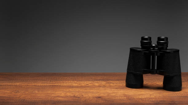 istock Vintage black binoculars on wood table and gray background with texting space, travelling concept. 1147786420