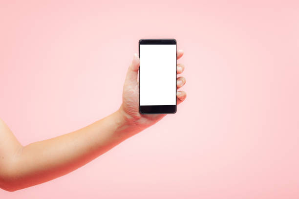 istock Hand holding smartphone with white blank screen on pink background, technology concept. 1147786957