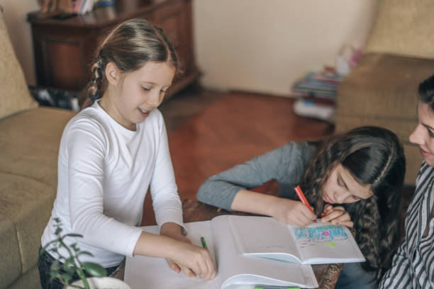 istock Mother and her two daughters doing homework at home 1147787421