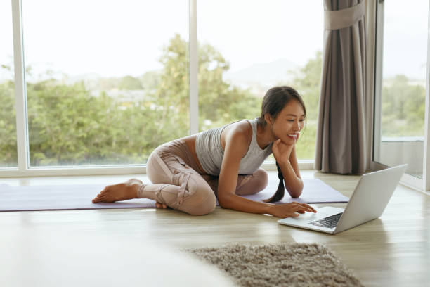 istock Smiling girl using computer sitting on floor at home 1147787650