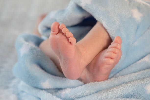 istock Baby feet on blue coverlet 1147788305