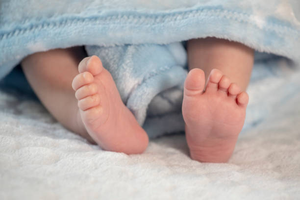 istock Baby feet on blue coverlet 1147788306