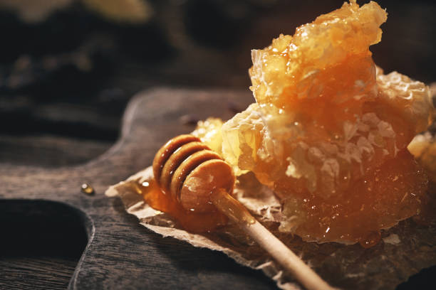 Honeycomb and bamboo dipper on wooden table