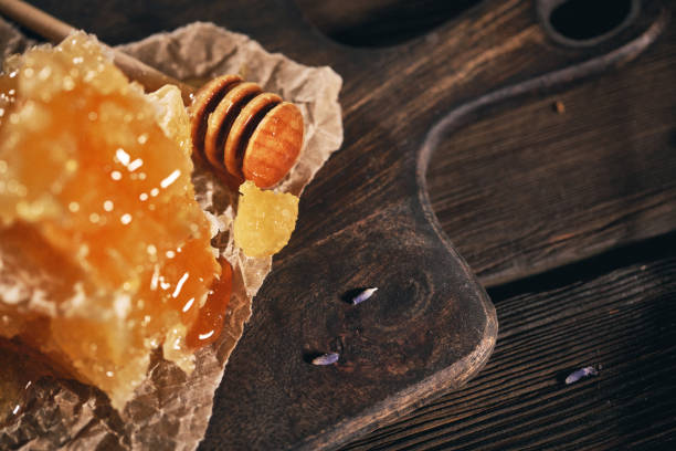 istock Honeycomb and bamboo dipper on wooden table 1147788974