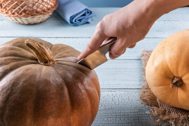 istock Cutting whole orange pumpkin with metal knife 1147789140