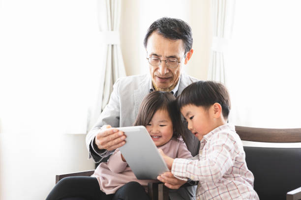istock Grandfather and grandchildren using a tablet pc together 1147789304