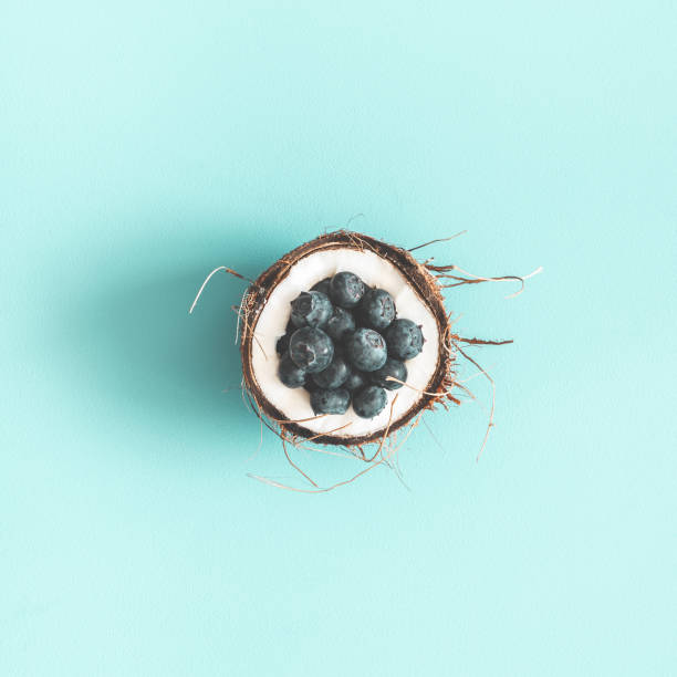 istock Coconut and blueberry on blue background. Flat lay, top view, square 1147790275