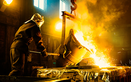 Worker controlling metal melting in furnaces. Workers operates at the metallurgical plant.