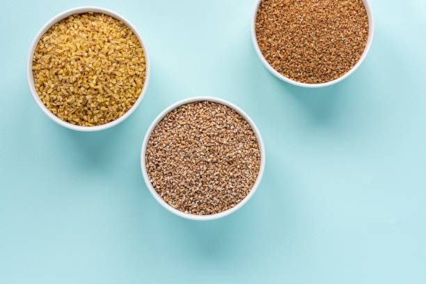 istock Uncooked crushed spelt, wheat and bulgur in a white bowl on pastel blue background 1147794874