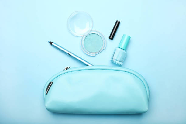 cosmetic bag with set of women's cosmetics Blue cosmetic bag with set of women's cosmetics on blue background. Concept makeup, make-up artist. Top view. make up bag stock pictures, royalty-free photos & images