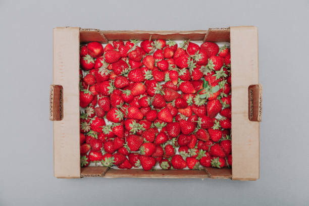 istock Red ripe strawberries in cardboard box on white background 1147799097