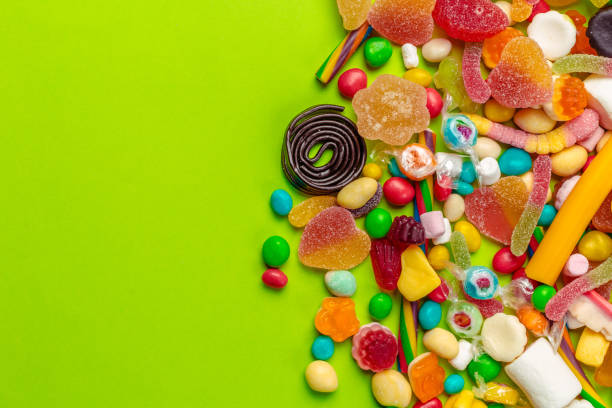 istock Colorful candies on green background 1147800372