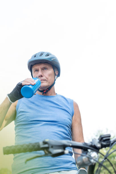 istock Determined rider drinking water in park against sky 1147804733