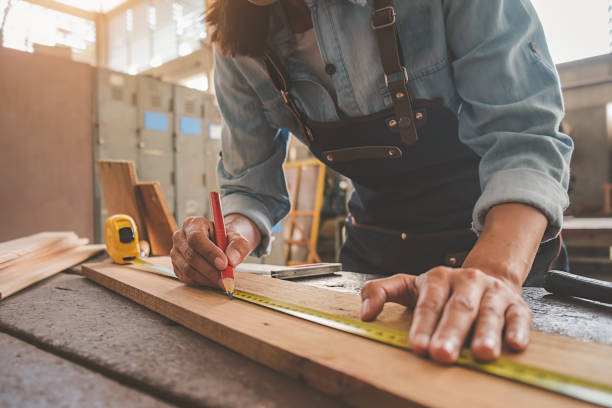 charpentier travaillant avec l’équipement sur la table en bois dans le magasin de menuiserie. femme travaille dans un atelier de menuiserie. - work tool carpentry construction wood photos et images de collection