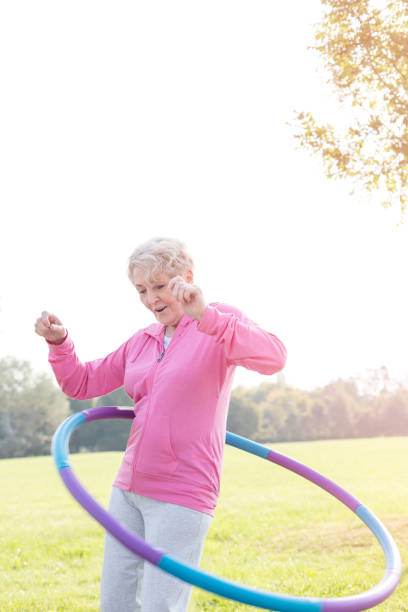 istock Active senior woman hula hooping in park 1147805058