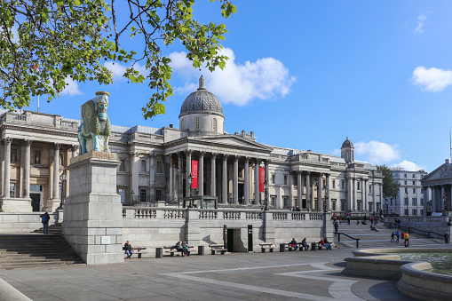 4th May, 2019 - Tourist walking by The National Gallery in Trafalgar Square, London, UK on a sunny Saturday morning