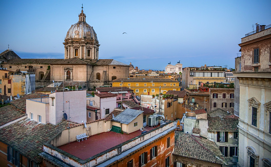 Rome, Italy, May 07 - A warm light of a spring sunset illuminates the roofs of Rome, with the splendid Renaissance dome of the church of Sant'Andrea della Valle in the foreground, near Piazza Campo dei Fiori, and on the bottom the white silhouette of the Altar of the Fatherland, the national monument dedicated to King Vittorio Emanuele II and the Italian soldiers who died in the First World War.