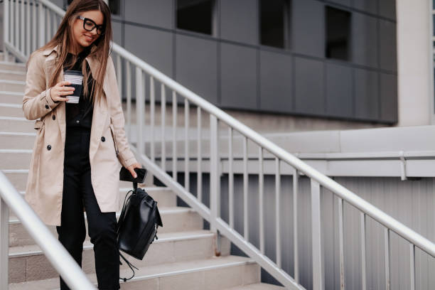 istock Woman outside business center drinking coffee 1147808033