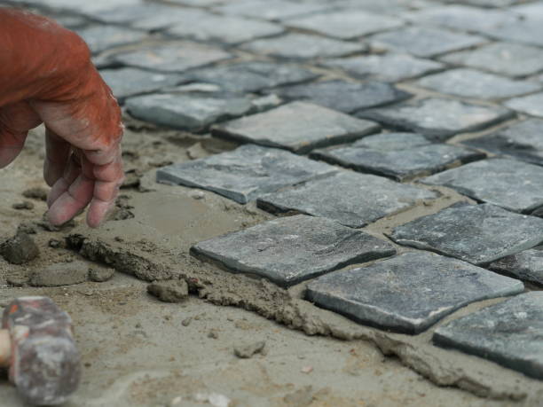 istock Hand of mason worker making sidewalk with stone blocks 1147808130