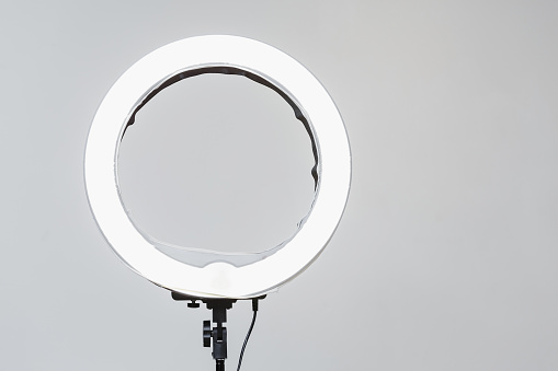 Closeup of circular neon LED lamp at white background. Popular modern light for make-up and beauty portraits