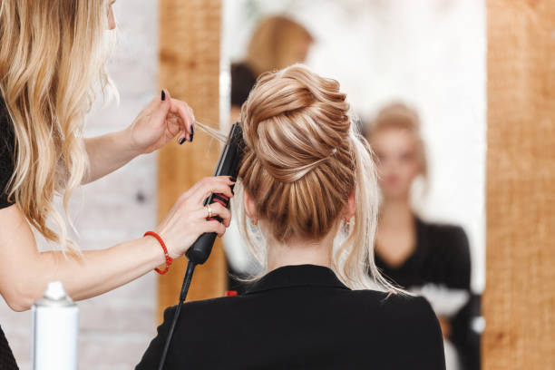 mujer de negocios señora jefa en salón de belleza haciendo vestido de peluquería y mirando al espejo - salón de belleza fotografías e imágenes de stock