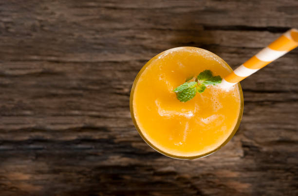 istock Mango smoothies  juice and fruit mango drink in a glass drink orange colorful fruit juice milkshake blend beverage healthy high protein the taste yummy in glass on wood background from the top view. 1147811483