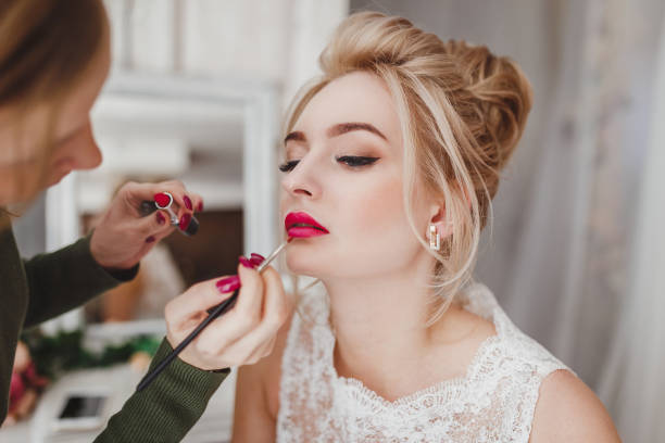 professional stylist doing make-up for blonde woman - hairstyle love wedding photography imagens e fotografias de stock