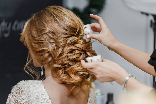 Hair Stylist Or Florist Makes The Bride A Wedding Hairstyle With Fresh  Cotton Flowers Stock Photo - Download Image Now - iStock