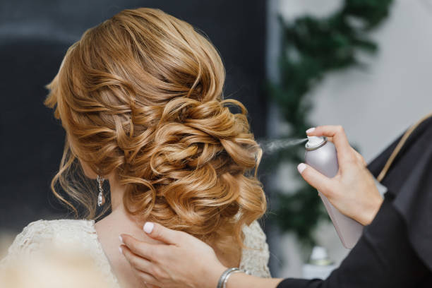 istock Master stylist makes the bride wedding hairstyle using spray lacquer fixing 1147811835