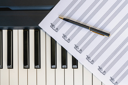 Top View of Piano Keyboard with Sheet Music and Pen, Concept, Copy Space