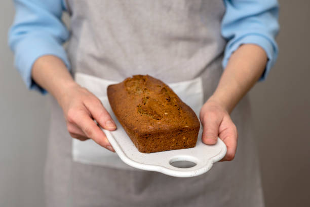 istock Women's hands holding freshly baked cake, bread with grains and seeds. 1147817842