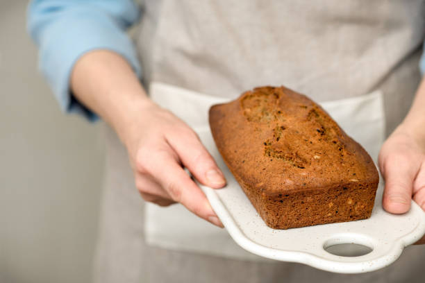 istock Women's hands holding freshly baked cake, bread with grains and seeds. 1147817845