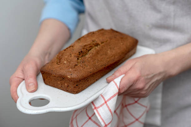 istock Women's hands holding freshly baked cake, bread with grains and seeds. 1147817848