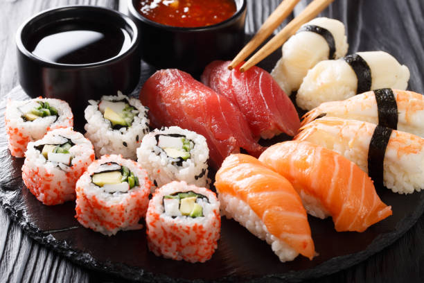 variedad de comida de sushi. nigiri, maki, uramaki y roll con atún, salmón y camarones. comida asiática con pescado crudo y arroz. horizontal - sushi restaurant fish japanese culture fotografías e imágenes de stock