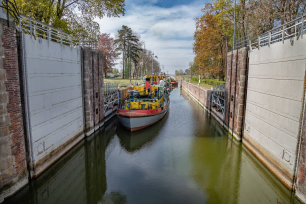 sluice, porta da água com os rebocadores coloridos estacionados ao longo do ancoradouro em sobieszewo em poland. - barge canal construction engineering - fotografias e filmes do acervo