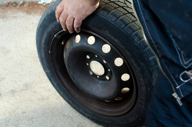 istock auto mechanic man holding old black rubber tire close up 1147821210