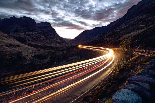 istock Light trails in the night on a remote road in mountains 1147821296