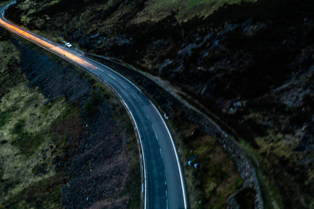 istock Light trails in the night on a remote road in mountains 1147821356