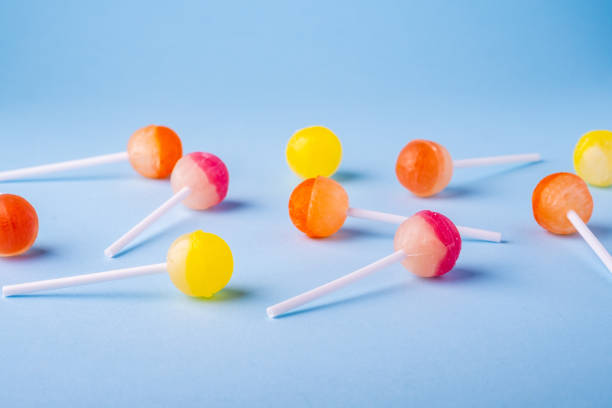 istock Scattered lollipop candies on blue background angle view 1147825093