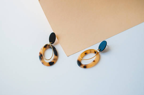 istock Earrings on beige and brown color background. 1147826405