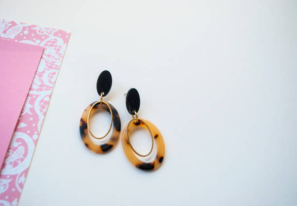 istock Earrings on beige and brown color background. 1147826414