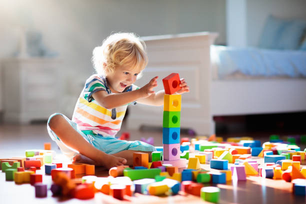 Child playing with colorful toy blocks. Kids play. stock photo