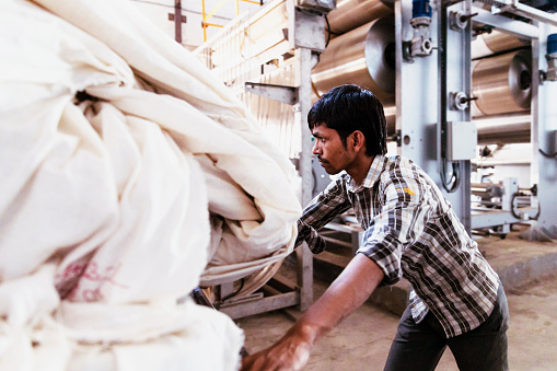 Textile, Industry, India - A Factory Worker Pushing to the Fabric Dyeing Machine
