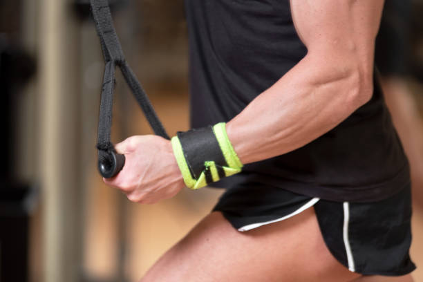 istock Young fit muscular man close up doing triceps pull down rope extension exercise in modern fitness center. 1147829215