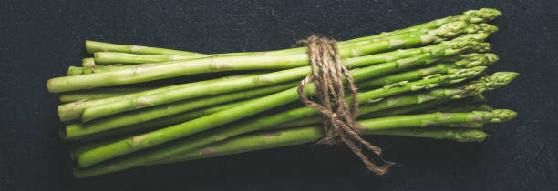 istock Fresh green asparagus on dark concrete background 1147829241